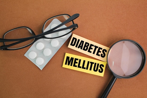 glasses medicine and magnifying glass with the word diabetes mellitus concept of medicine