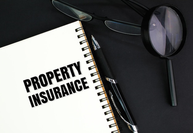 glasses a pen a magnifying glass and a book with the word Property Insurance insurance coverage