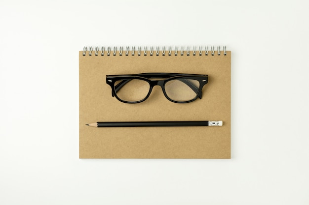 Glasses, pencil on a notebook - for business concept background