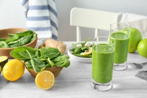 Glasses of spinach smoothie on table