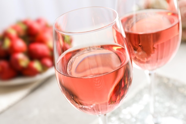 Glasses of strawberry wine on table