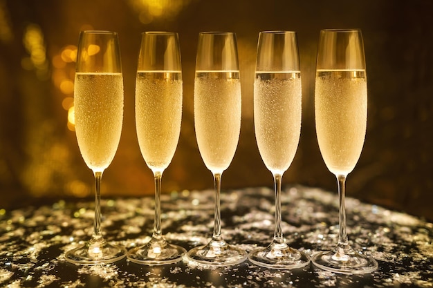 Glasses with champagne on a black background.Vintage tone