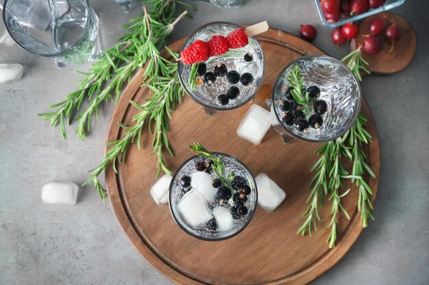 Glasses with fresh rosemary drink on wooden board