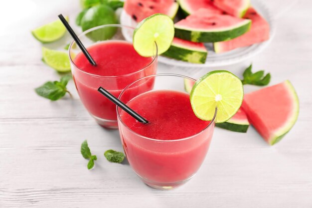 Glasses with fresh watermelon smoothie on wooden table