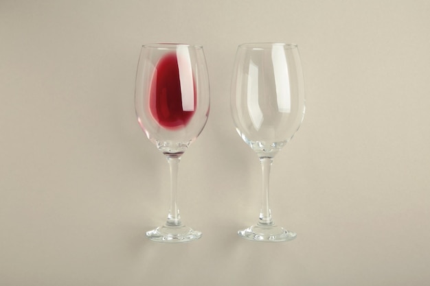 Glasses with red wine lying on grey background Flat lay