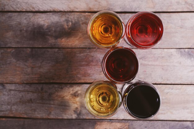 Glasses with wines of different colors on a wooden table