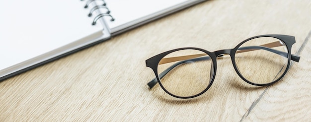 Glasses at the workplace in the office near the notepad Business hours