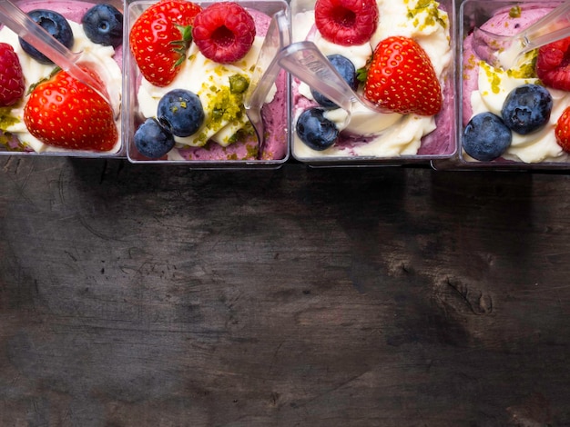 Glasses of yogurt with berries strawberry blueberry raspberry and nuts pistachios food closeup