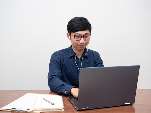 Glassses man using laptop for working on table his workspace room