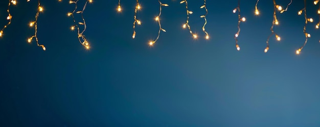 Photo glistening string lights against blue background enchanting atmosphere for festive romantic events