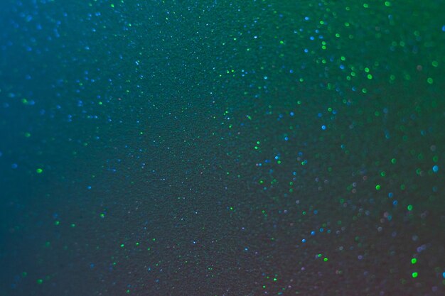 Glitter background bokeh light blue green grain