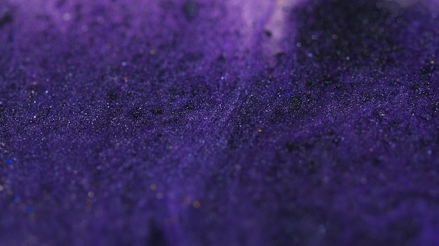 Glitter fluid texture sparkling paint defocused purple black color shiny sequin particles pigment