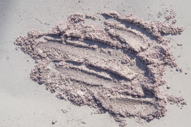 Glittering pink and silvery stroke eye shadow scattered over white background