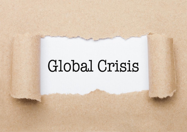 Global Crisis concept text appearing behind torn brown paper envelope