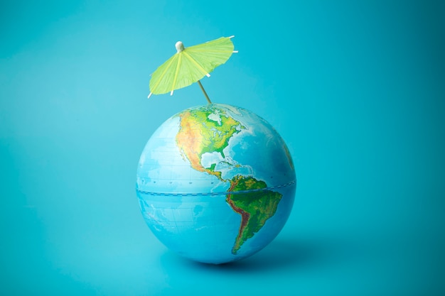 Global warming and climate change on earth concept. Earth globe with an umbrella. Protecting the atmosphere from ultraviolet radiation and ozone holes