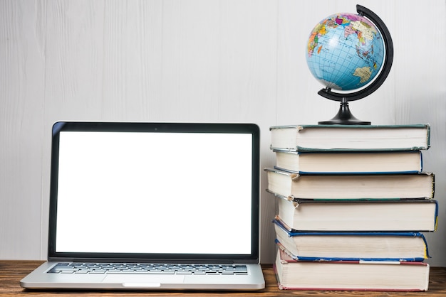 Globe and books near laptop