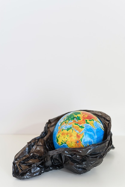 The globe is wrapped in plastic on a white background. concept of pollution by plasticon planet.