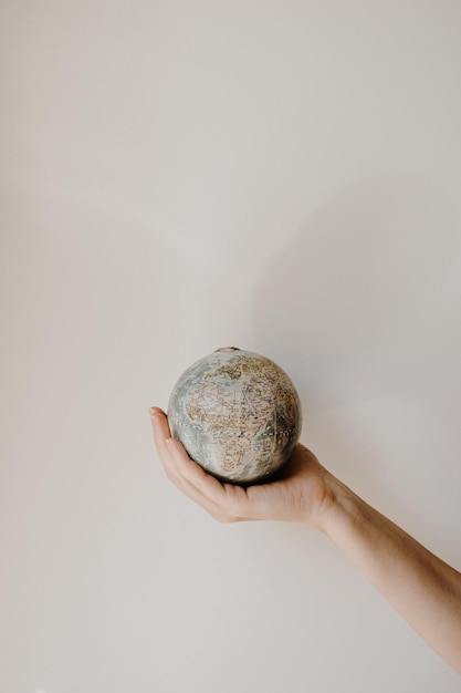 Globe model in female hand on white background Save the world planet Earth concept Women's rights and power concept