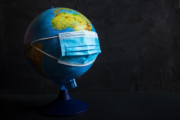 Photo globe in a protective medical mask. coronavirus attacks the planet.