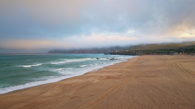 Gloomy sea surf evening nature in slow motion sunset with low hanging clouds