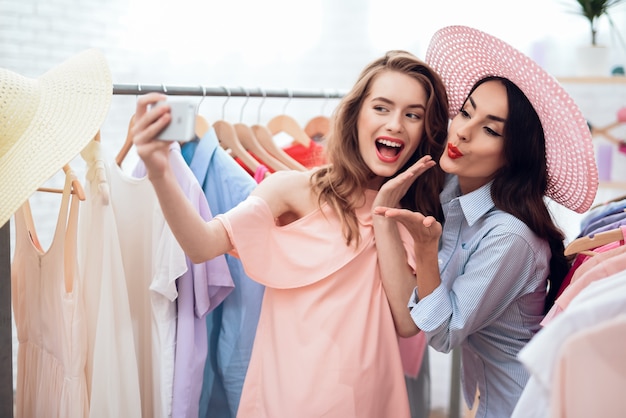 Glorious girls look at the clothes in the showroom.