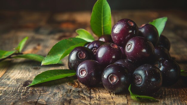 Photo glossy deep purple jaboticaba fruits and green leaves arranged on rustic wooden table