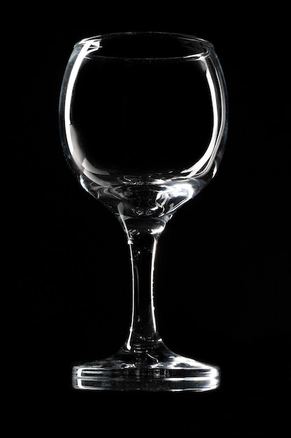 Glossy empty wine glass close up on a dark background