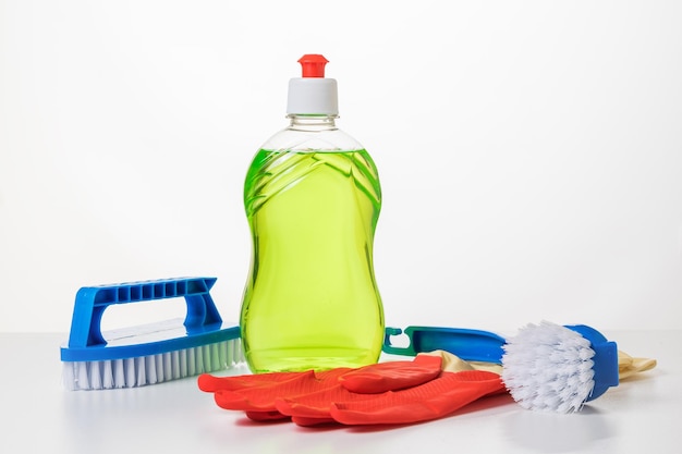 Gloves brushes and cleaning gel on a white table