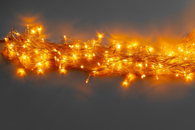 Glowing golden electric garland on a gray 