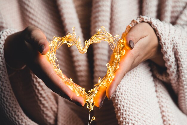 Photo glowing heart in the hands of a woman. happy valentine's day.