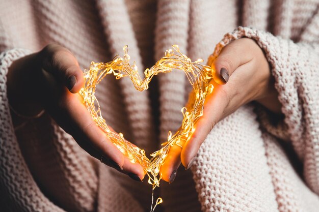 Photo glowing heart in the hands of a woman happy valentines day