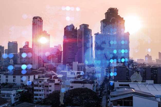 Glowing hologram of Earth planet map on aerial panoramic cityscape of Bangkok at sunset Asia The concept of international business Multi Exposure