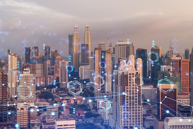 Glowing hologram of technological process aerial panoramic cityscape of Kuala Lumpur at sunset KL is the largest innovative hub of tech services in Malaysia Asia Multi exposure