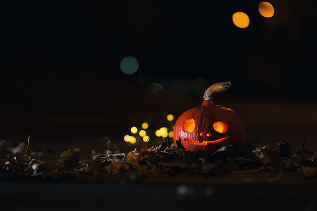 Glowing mystical Halloween pumpkin on the road at night