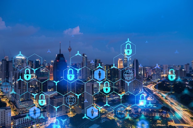 Glowing padlock hologram night panoramic city view of Kuala Lumpur Malaysia Asia The concept of cyber security shields to protect KL companies Double exposure