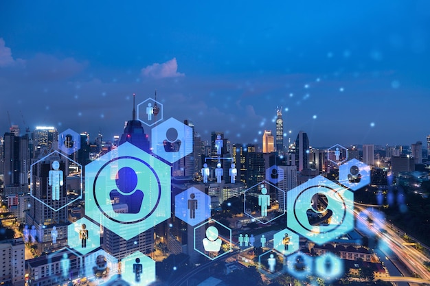 Glowing social media icons on night panoramic city view of Kuala Lumpur Malaysia Asia The concept of networking and establishing new connections between people in businesses in KL Double exposure