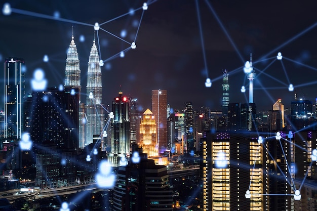 Glowing social media icons on night panoramic city view of Kuala Lumpur Malaysia Asia The concept of networking and establishing new connections between people in businesses in KL Double exposure