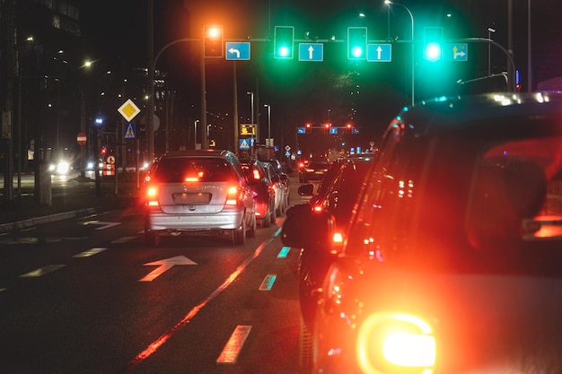 Glowing traffic lights and headlights from cars in the evening in the city Urban traffic