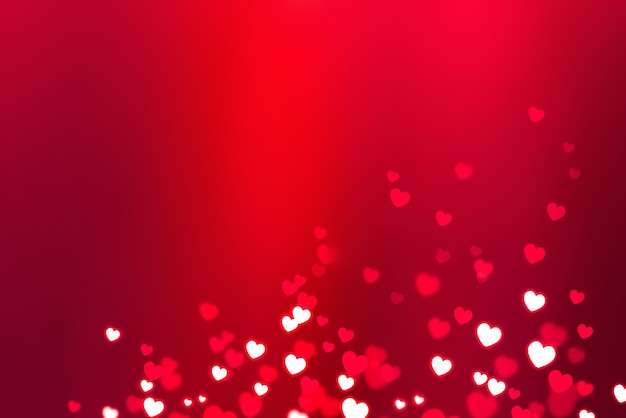 Glowing white hearts on a pink background with bokeh effect