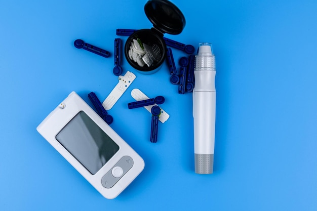 Glucometer isolated on a blue background Medical device for measuring sugar