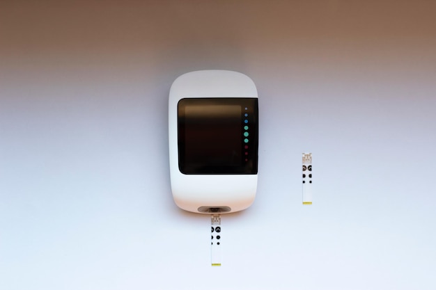 Glucose meter device for measuring blood sugar with test strips on an isolated background