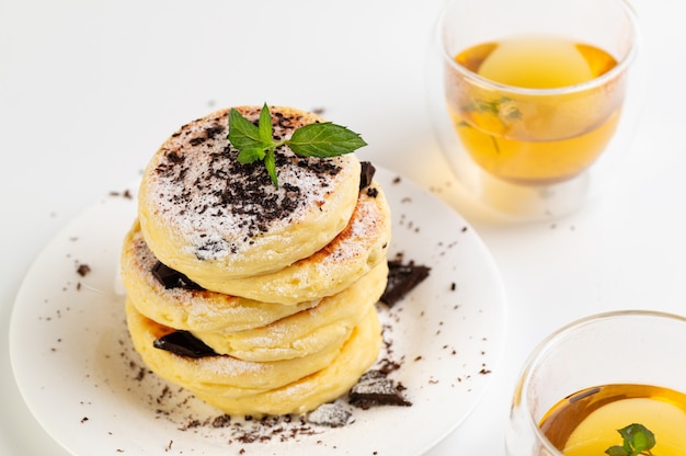 Gluten-free cheese cakes on coconut flour with chocolate and green tea, on a white background