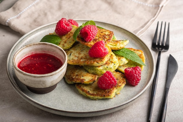 Gluten-free zucchini pancakes with raspberries and raspberry jam. Healthy food concept, summer food.