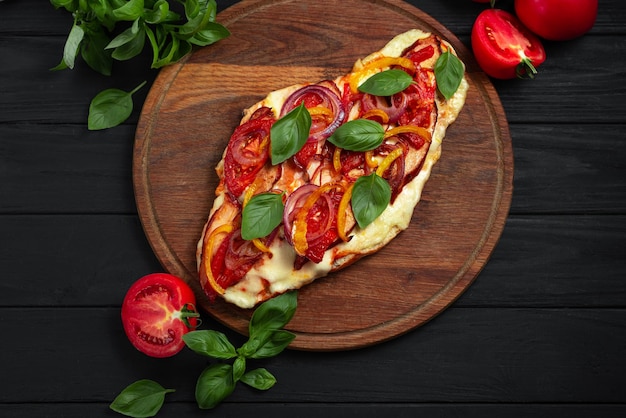 Glutenfree pizza flatbread top view pizza on a flatbread with vegetables on a black wooden backgroun