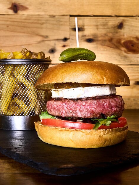 Photo goat cheese burger and fries on a slate board