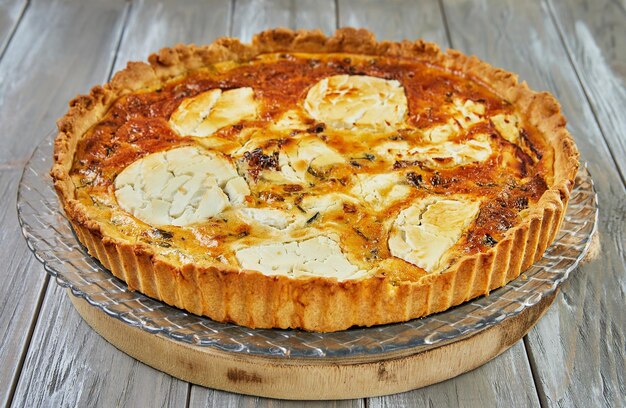 Goat cheese quiche on a wooden background French gourmet cuisine