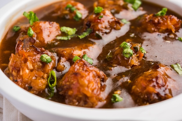 Gobi Manchurian dry or with gravy - Popular street food of India made of cauliflower florets, selective focus