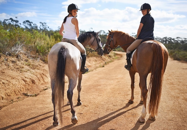 Going for a ride Rearview of two women on horseback