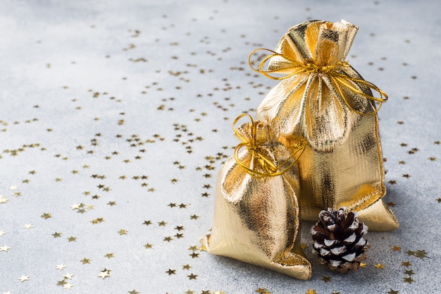 Gold bags with Christmas gifts on grey