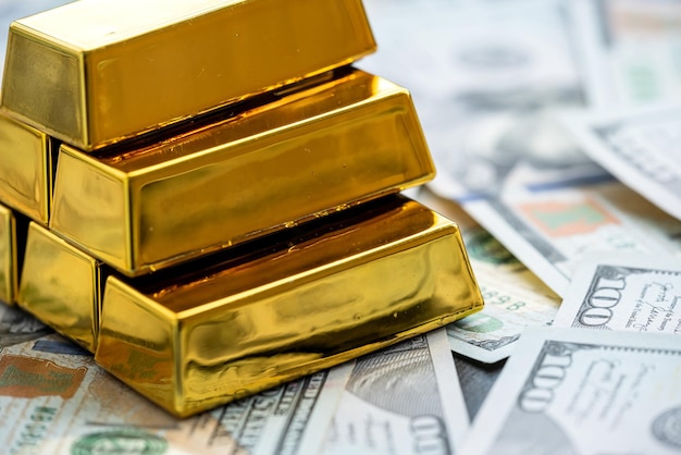 Gold bars above new 100 dollar banknotes Saving concept economy